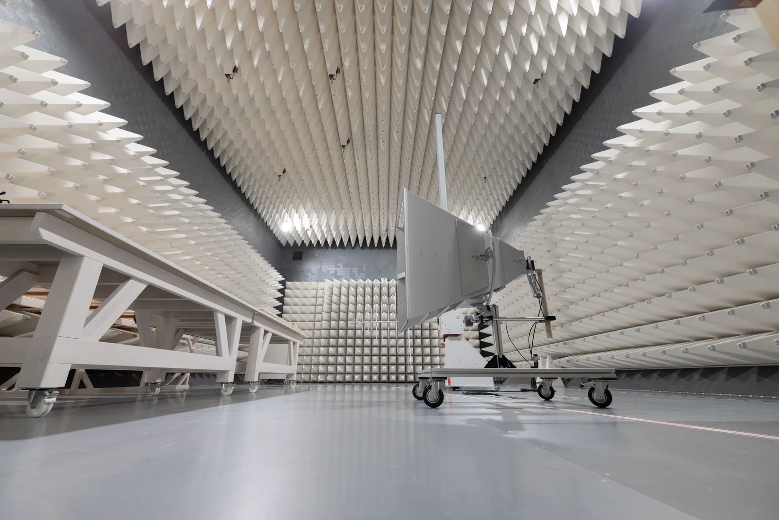 Schalltoter Raum mit pyramidenförmigen Schaumstoffplatten und einem mobilen Gerät mit Antenne.