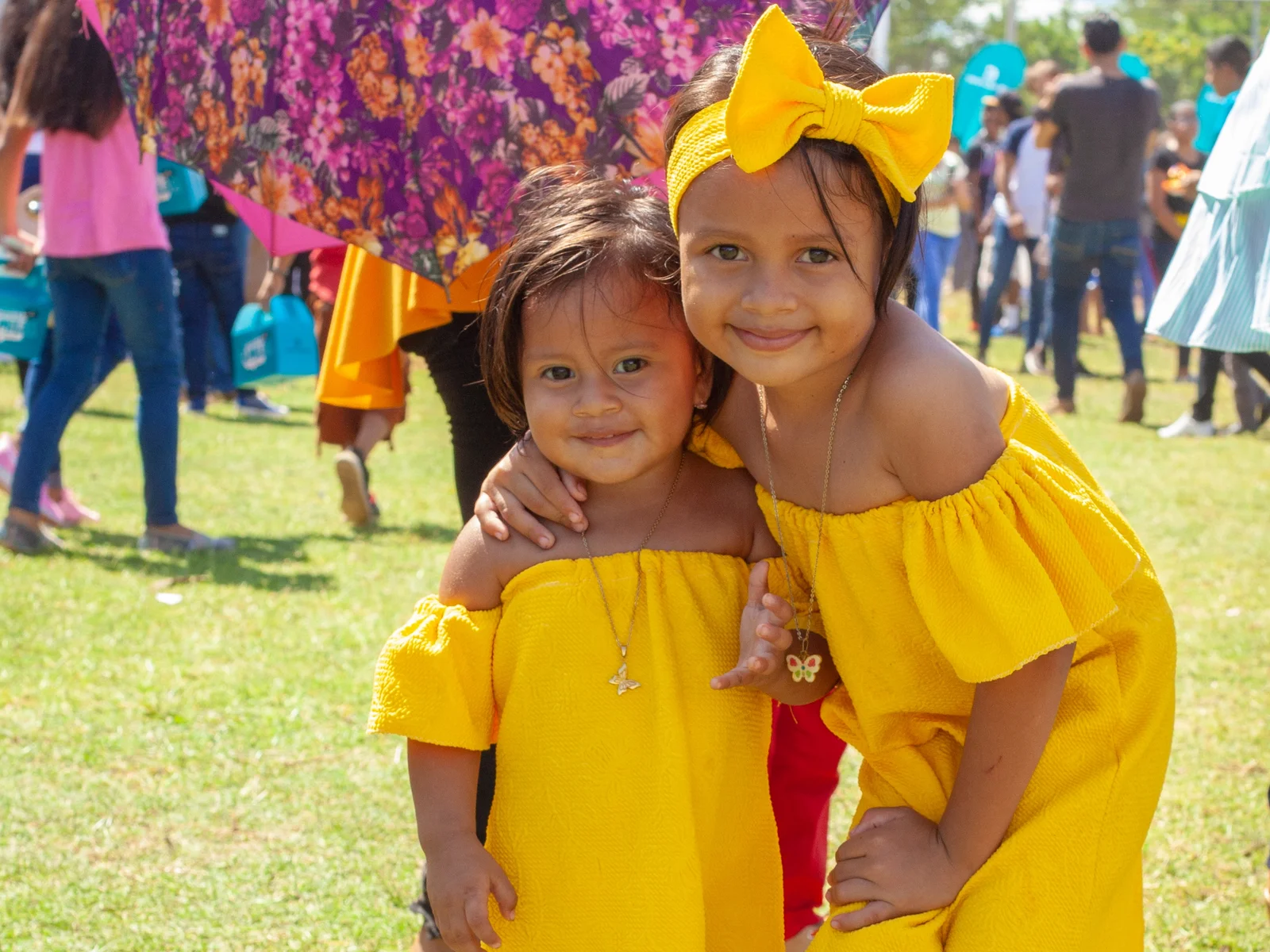 Two young girls in yellow dresses on a meadow at a family event in Nicaragua.